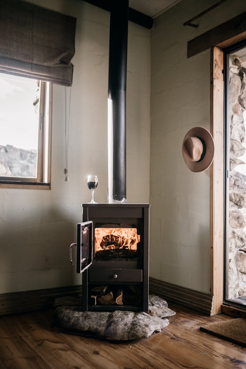Warm and inviting modern interior featuring a burning fireplace and glass of wine.